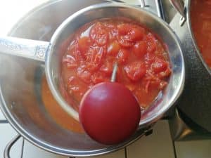 Puré de tomate en un molino de verduras de malla estrecha